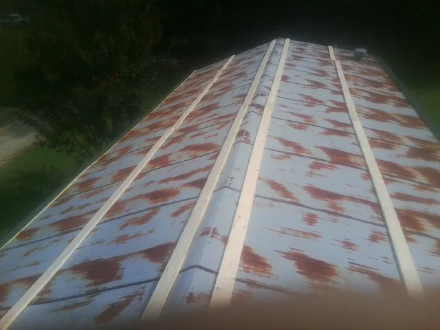 Rusted metal roof panels with new wood purlins before replacement — Storm Damage Roof Repair in Burnt Cabins by Roofing Brothers
