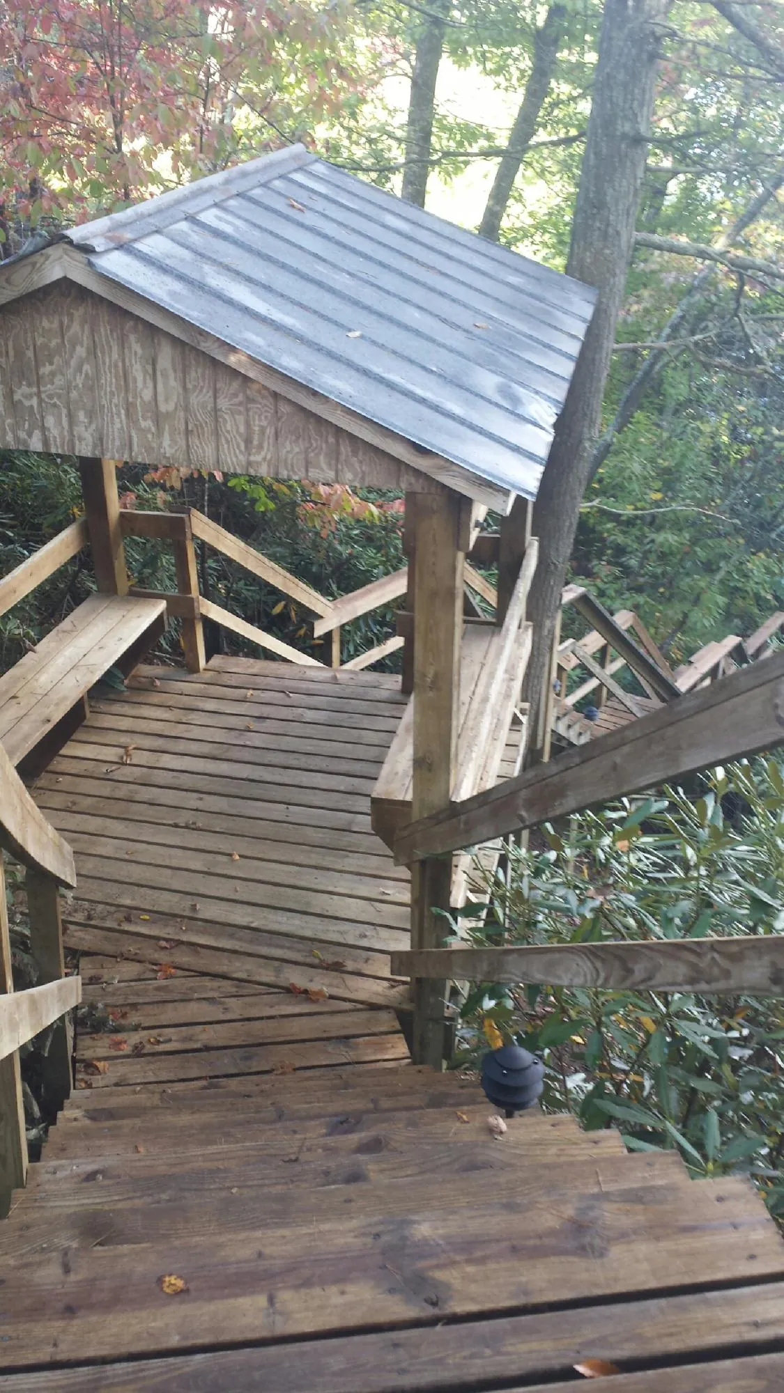 Metal roofed shelter over wooden steps on a wooded walkway — Skylight Repair & Installation work by our crew in Burnt Cabins