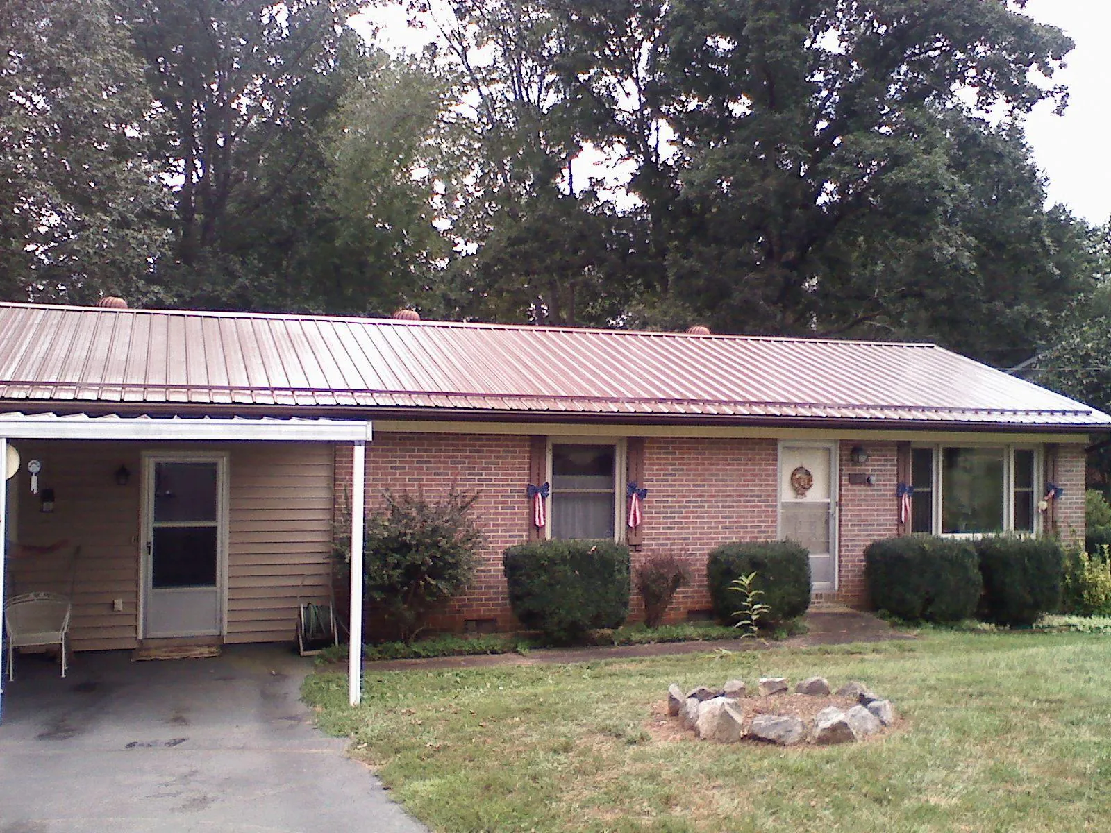 Bronze metal roof and carport on a brick ranch home — Roof Repair work by our crew in Burnt Cabins