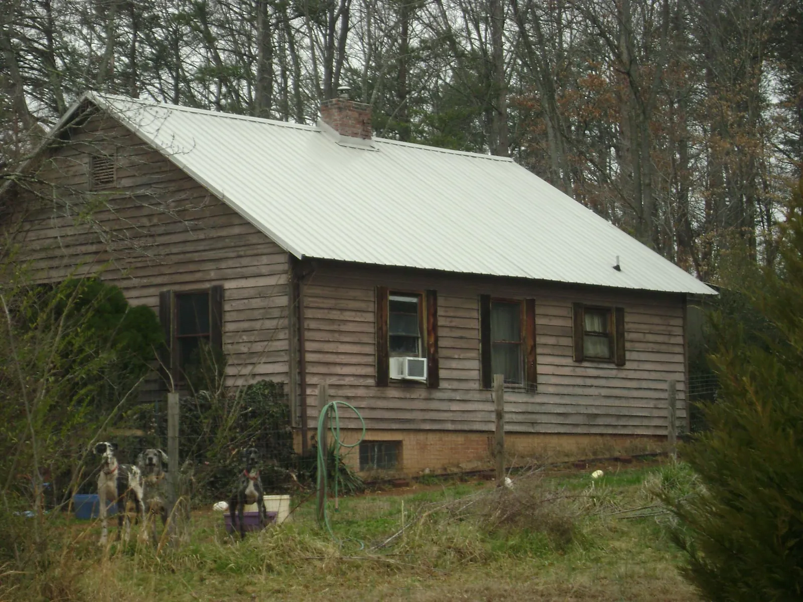 White metal roof on an old wood sided farmhouse, from a Metal Roof Installation job in Burnt Cabins